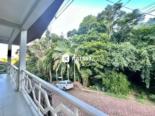 Varanda com vista para vegetação densa e árvores.