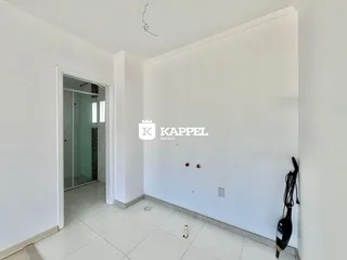 Hall de entrada com paredes brancas e piso de cerâmica claro.