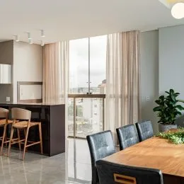Sala de jantar com mesa de madeira e armário escuro.