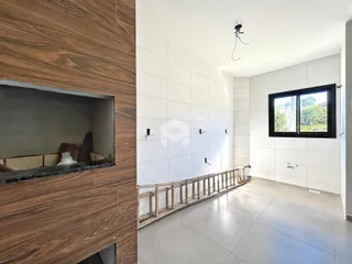 Ambiente interno de uma sala com piso claro e grade de madeira rústica.