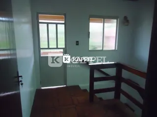 Vista de um corredor com piso de madeira e guarda-corpo.