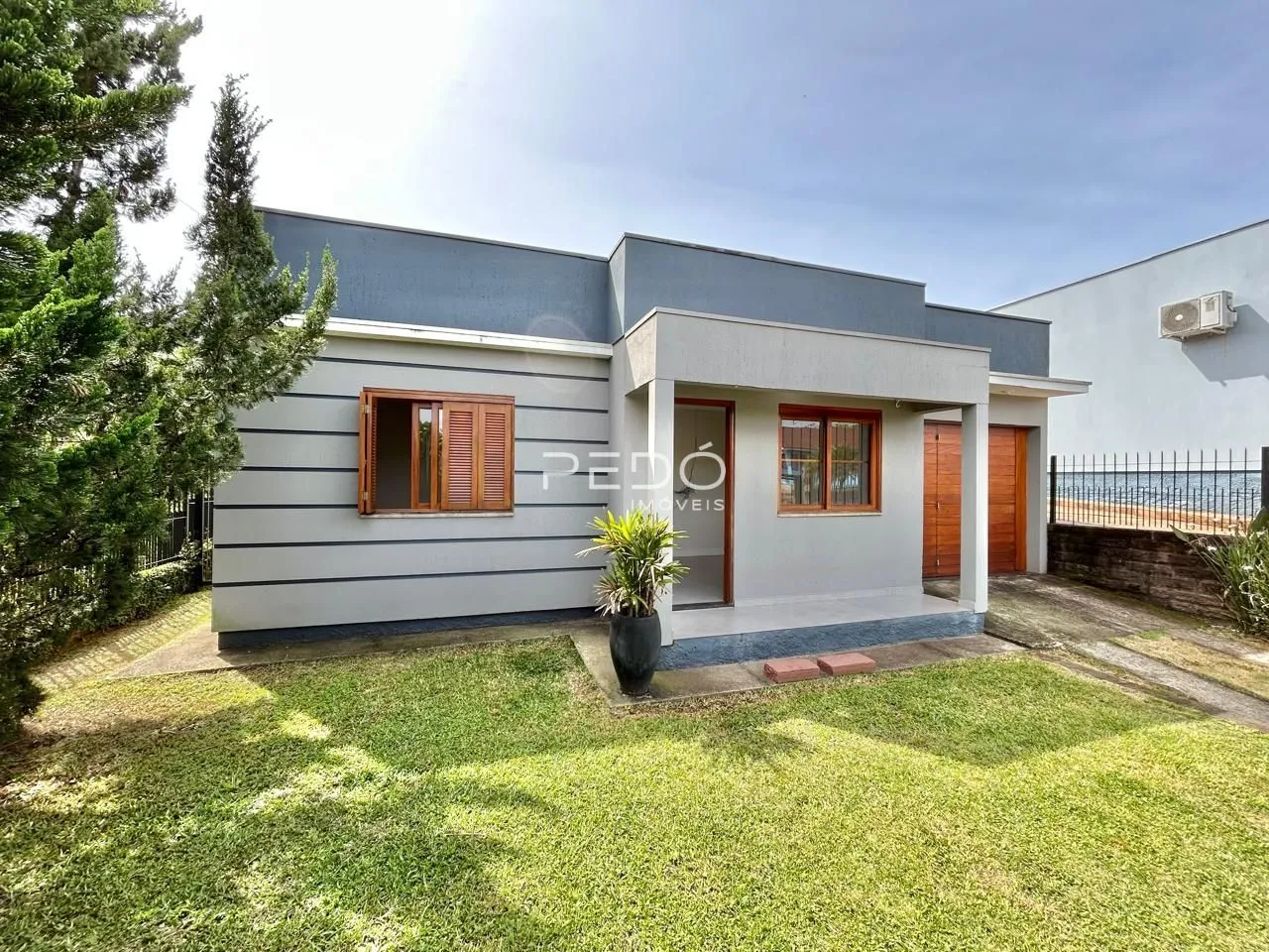 Fachada de uma casa moderna em Lajeado, Brasil com jardim gramado.
