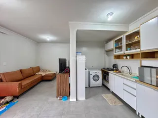 Sala de estar com ambiente aberto e cozinha integrada.