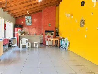 Ambiente interno de uma sala de estar com paredes de tijolo vermelho e piso claro.