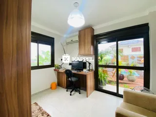 Escritório com mesa de trabalho e acesso a uma área externa.