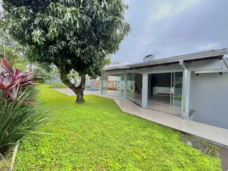 Vista externa de uma propriedade com jardim gramado e arquitetura moderna.