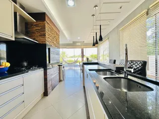 Vista da cozinha moderna com ilha e grandes janelas em Lajeado.