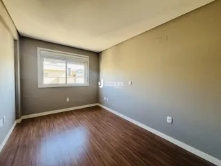 Ambiente interno com piso de madeira e paredes cinzas.