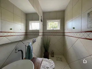 Interior de um banheiro com revestimento cerâmico e detalhes em ferro.