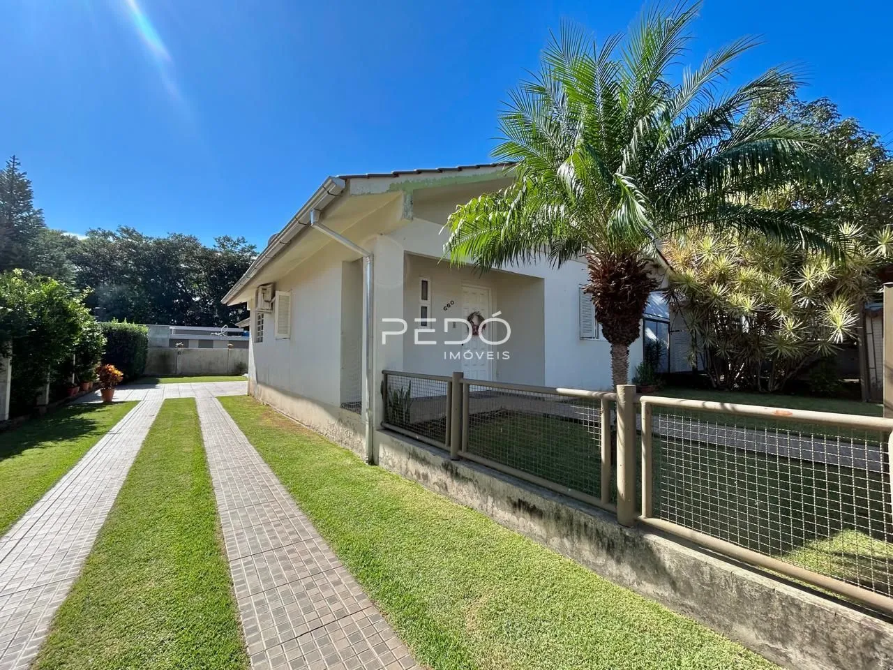 Fachada de uma casa em Lajeado, Brasil, com jardim e calçada.