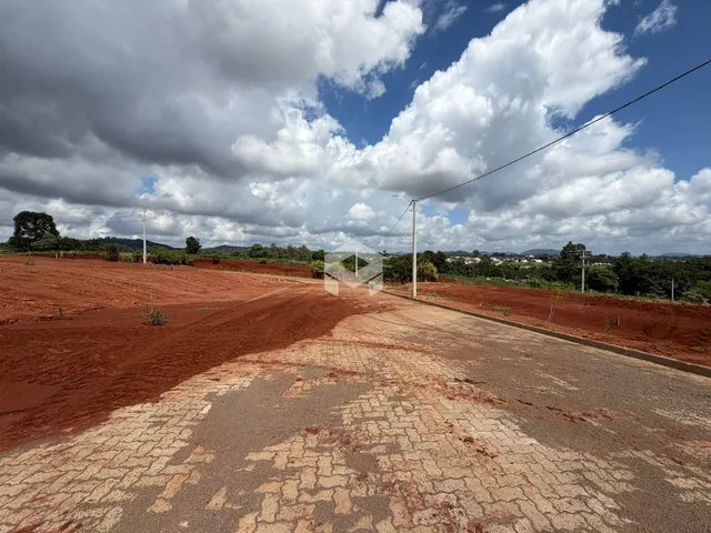 Vista da propriedade com terra vermelha e estrada de terra.
