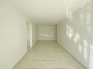 Corredor interno de uma residência com piso de cerâmica clara.