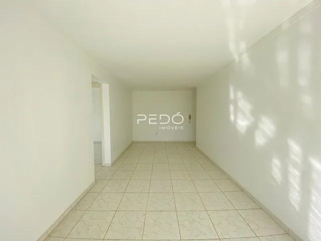 Corredor interno de uma residência com piso de cerâmica clara.