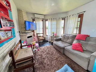Sala de estar com sofá e decoração de madeira em imóvel no Brasil.