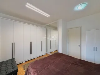 Quarto com armários embutidos e piso de madeira.