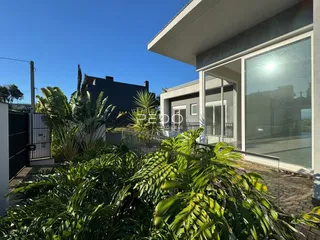 Fachada de uma casa moderna com jardim exuberante.