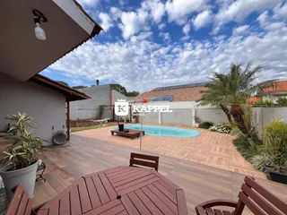 Área externa com piscina e deck de madeira em uma residência no Brasil.