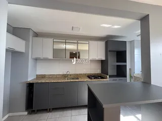 Vista da cozinha moderna com armários cinzas e bancadas claras.