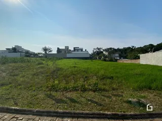 Vista aérea de uma área gramada com edifícios ao fundo.
