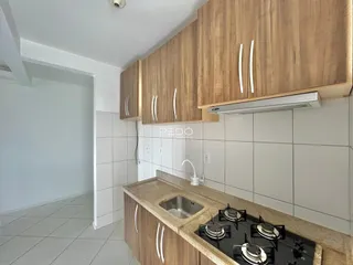 Cozinha com armários de madeira e bancada clara.