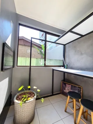 Vista interna de um ambiente com janela grande em uma residência.