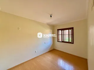 Uma sala de estar com piso de madeira e uma janela.