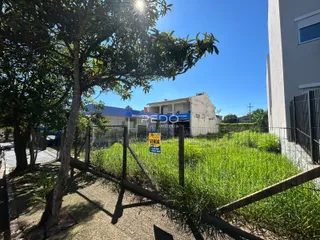 Vista da propriedade com cerca e vegetação ao ar livre.
