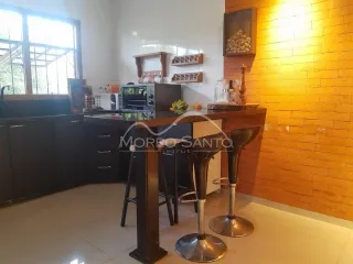 Foto de uma área de cozinha com armários escuros e balcão.