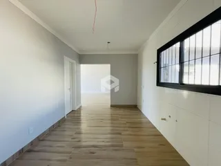 Corredor com piso de madeira e paredes brancas.