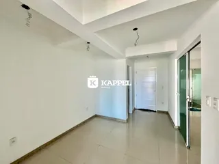 Hall de entrada de um apartamento branco com piso claro.