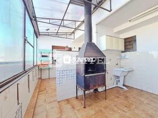 Foto interna de uma cozinha com piso de cerâmica e estrutura de metal exposta.
