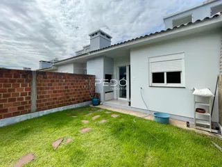 Fachada de uma casa em Lajeado, Brasil, com muro de tijolos e gramado na frente.