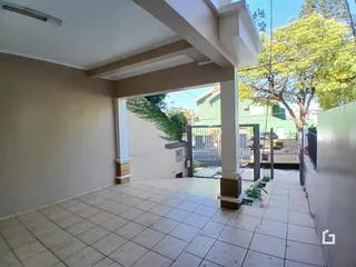 Área externa com piso de cerâmica e parede branca.