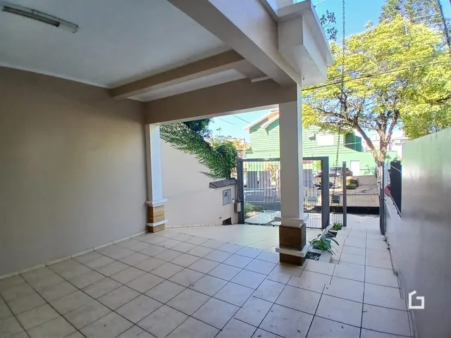 Área externa com piso de cerâmica e parede branca.
