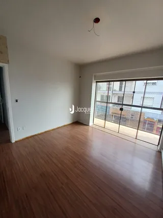 Sala de estar com piso de madeira e grande janela.