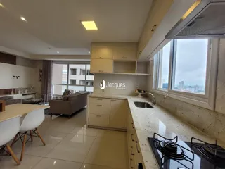 Ambiente de sala de estar e cozinha com vista para a cidade.
