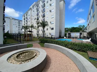 Vista externa de um complexo residencial com área de piscina e paisagismo.