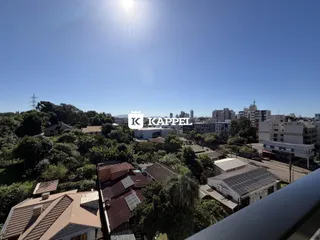 Vista aérea de uma área residencial com telhados e vegetação em Lajeado.