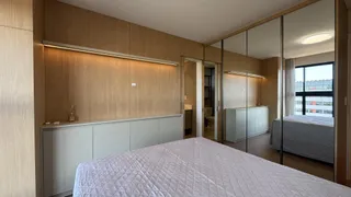 Quarto com cama grande e painéis de madeira na sala de um imóvel.