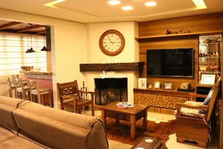 Sala de estar com lareira e televisão em ambiente residencial.