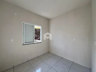 Vista interna de um cômodo com piso de cerâmica e janela.