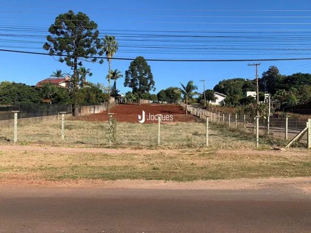 Vista externa da propriedade com cerca e vegetação no campo.