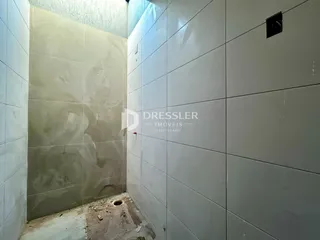 Parede interna com acabamento de azulejo e parte de alvenaria aparente em um imóvel.