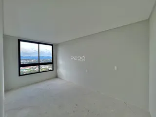 Ambiente interno de uma sala com grande janela de vista para a paisagem.
