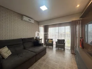 Sala de estar com sofá e poltronas em um apartamento no Brasil.