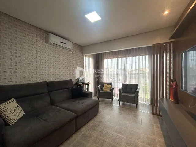 Sala de estar com sofá e poltronas em um apartamento no Brasil.