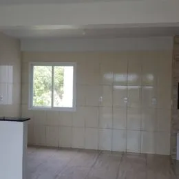 Foto de um interior com paredes claras e uma janela.