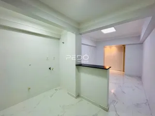 Um corredor interno com paredes brancas e piso de mármore claro é visível na propriedade.