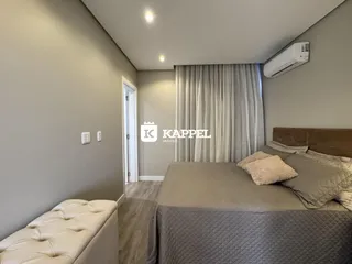 Quarto com cama grande e cortinas claras.