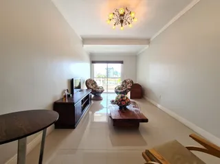 Sala de estar com piso claro e iluminação de teto.